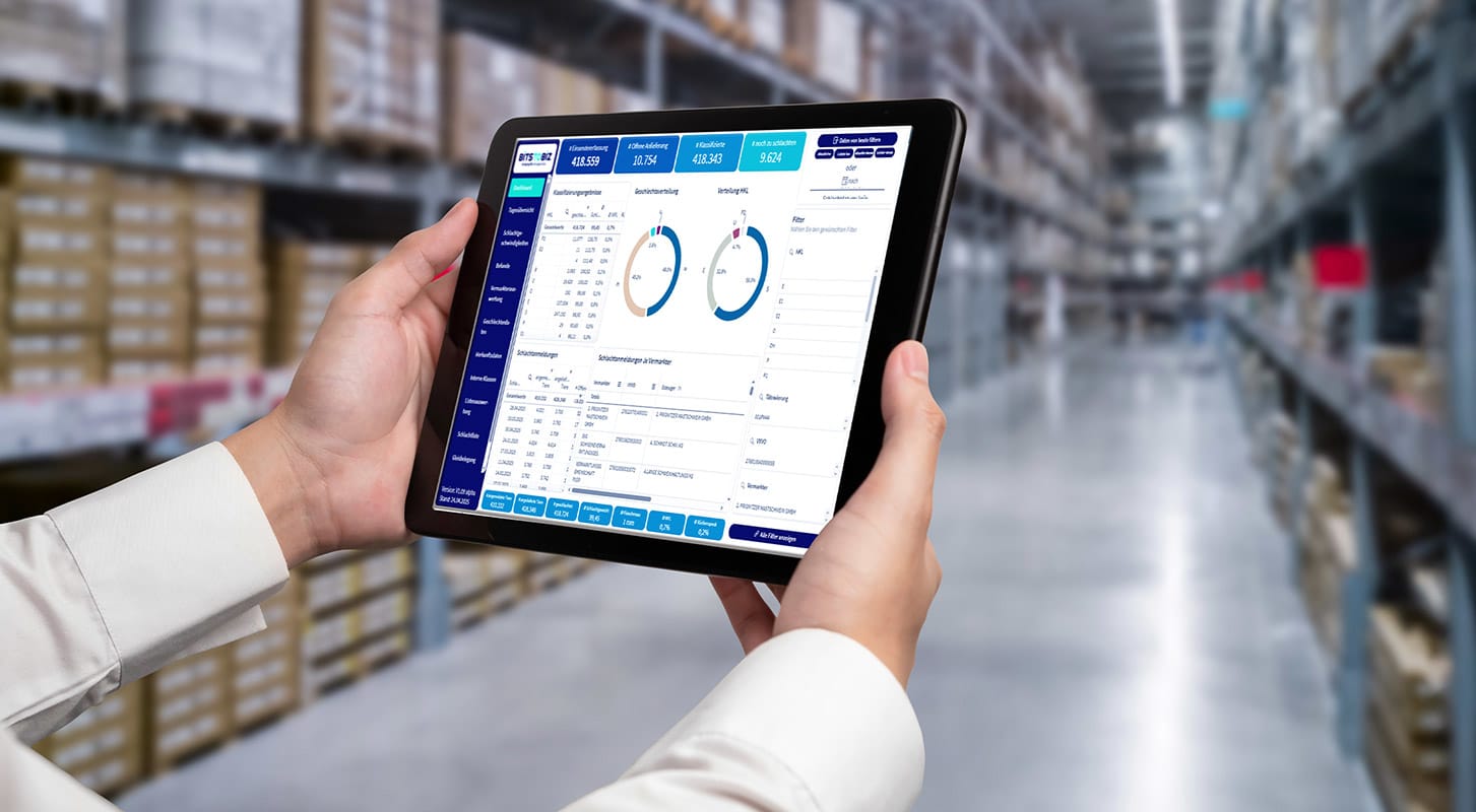 Individual analyzing data on a tablet, using Qlik Predict for demand forecasting and production planning in a warehouse setting.